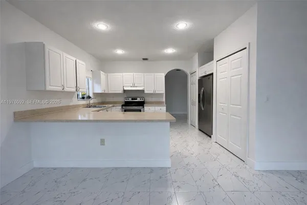 a kitchen with stainless steel appliances granite countertop a refrigerator and a stove