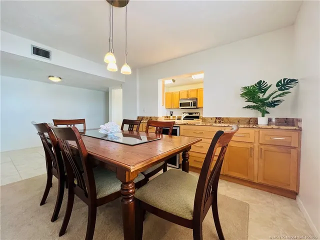 a dining room with furniture and a floor to ceiling window
