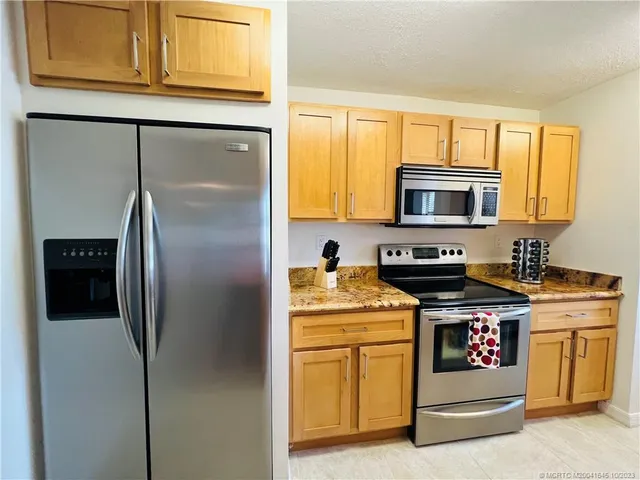 a kitchen with stainless steel appliances granite countertop a stove and a microwave