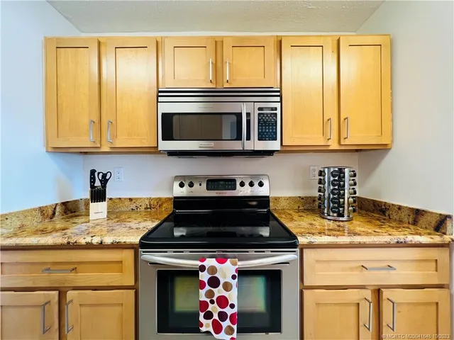a large kitchen with stainless steel appliances granite countertop a stove and a sink