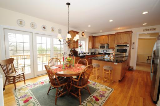 2706 Rondi Court Spring Grove, IL 60081 - Photo 5 of 14 a dining room with stainless steel appliances kitchen island granite countertop a table chairs and a refrigerator