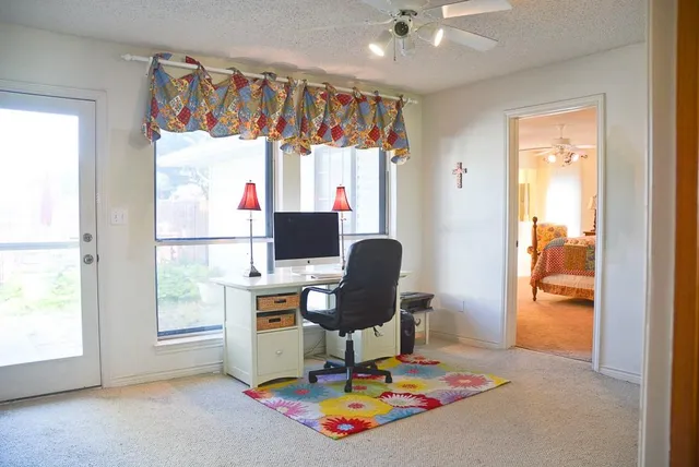 a view of a workspace with furniture and a window