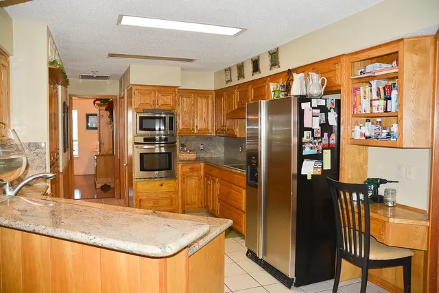 a kitchen with stainless steel appliances granite countertop a refrigerator and a sink