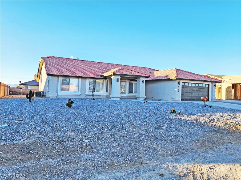4591 Stoneham Street Pahrump, NV 89061 - Photo 2 of 42 A terracotta-tiled roof and desert landscaping define this appealing single-story residence.