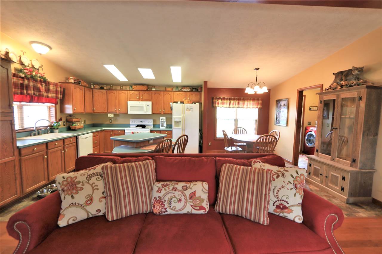 954 Quick's Mill Road Staunton, VA 24401 - Photo 26 of 45 a kitchen with stainless steel appliances granite countertop a refrigerator a stove top oven and a dining table with wooden floor