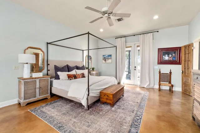 a bedroom with a bed a table and painting on the wall