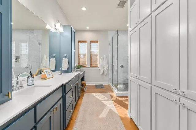 a bathroom with a double vanity sink and mirror with shower
