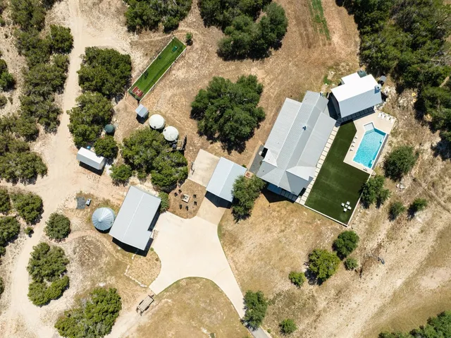 an aerial view of a house with a yard and sitting area