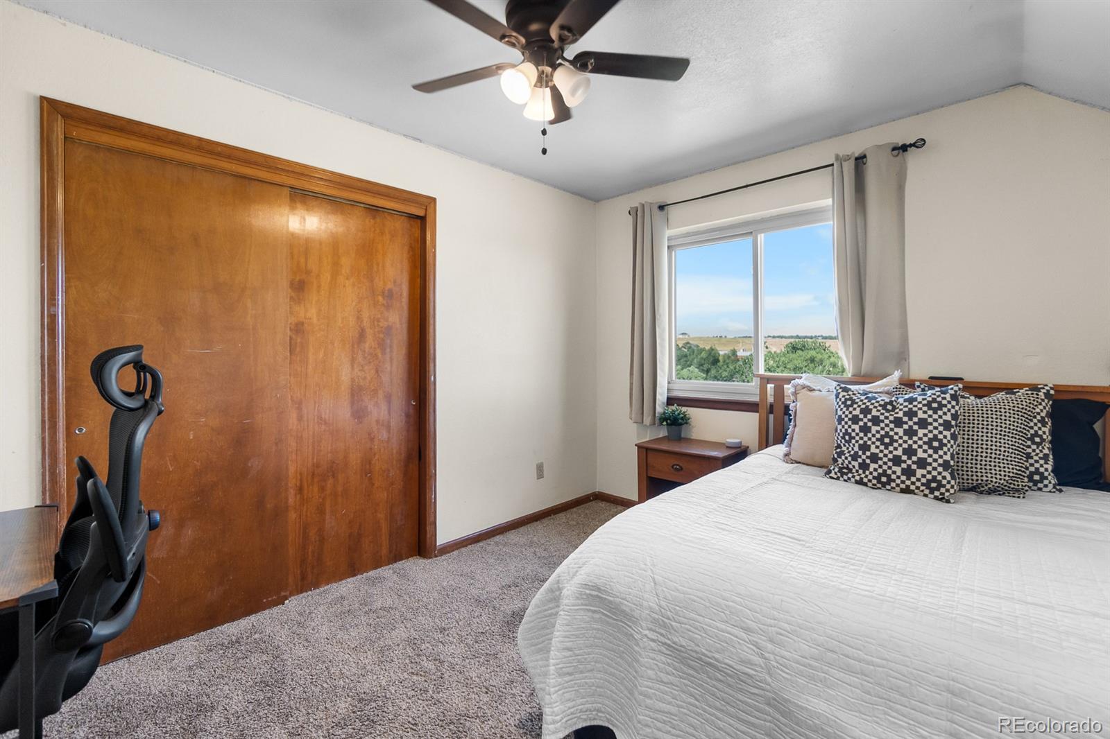 3163 Windstream Lane Elizabeth, CO 80107 - Photo 17 of 48 a bedroom with a large bed and a window