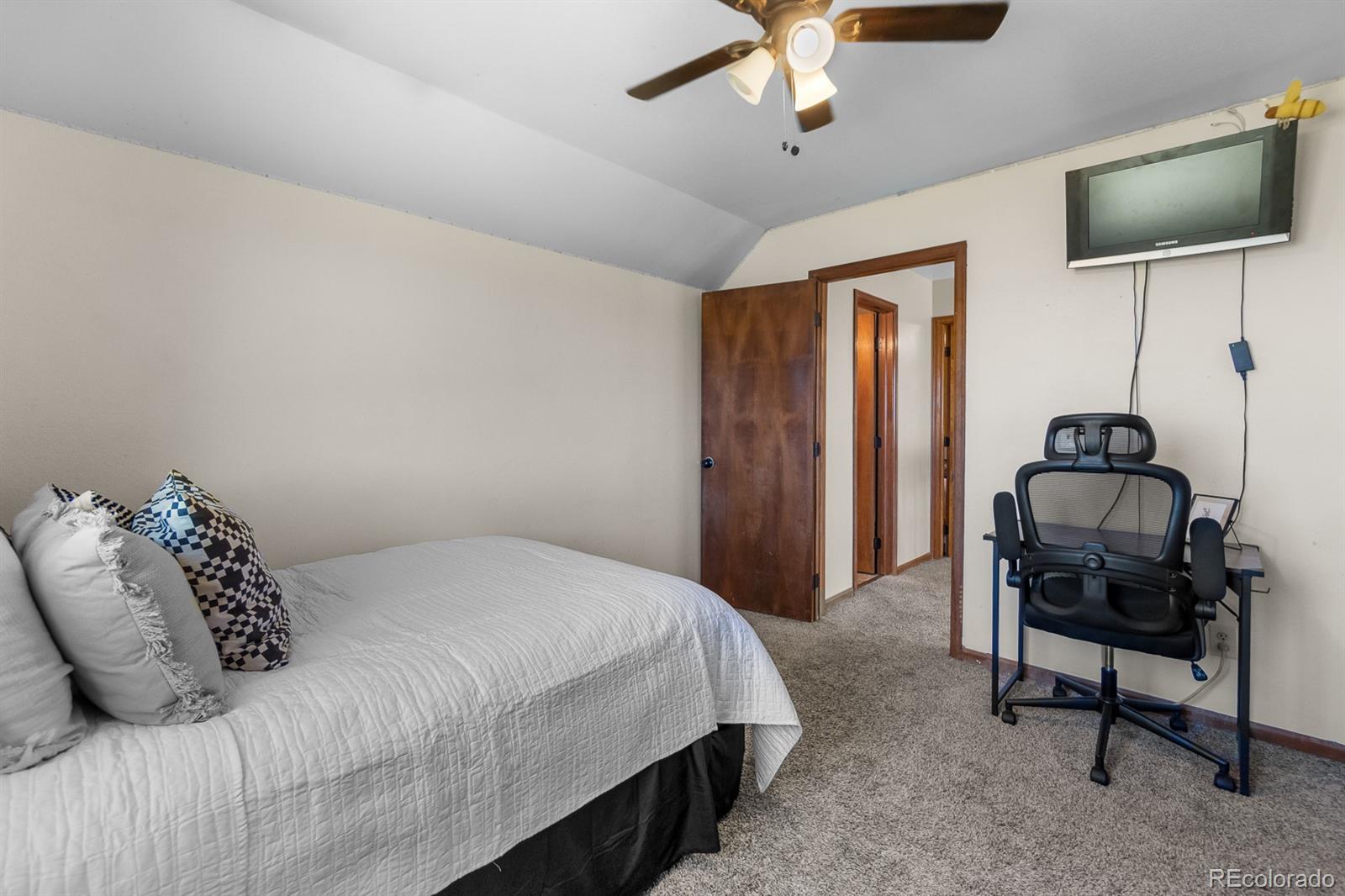 3163 Windstream Lane Elizabeth, CO 80107 - Photo 18 of 48 a bedroom with a bed and a flat screen tv
