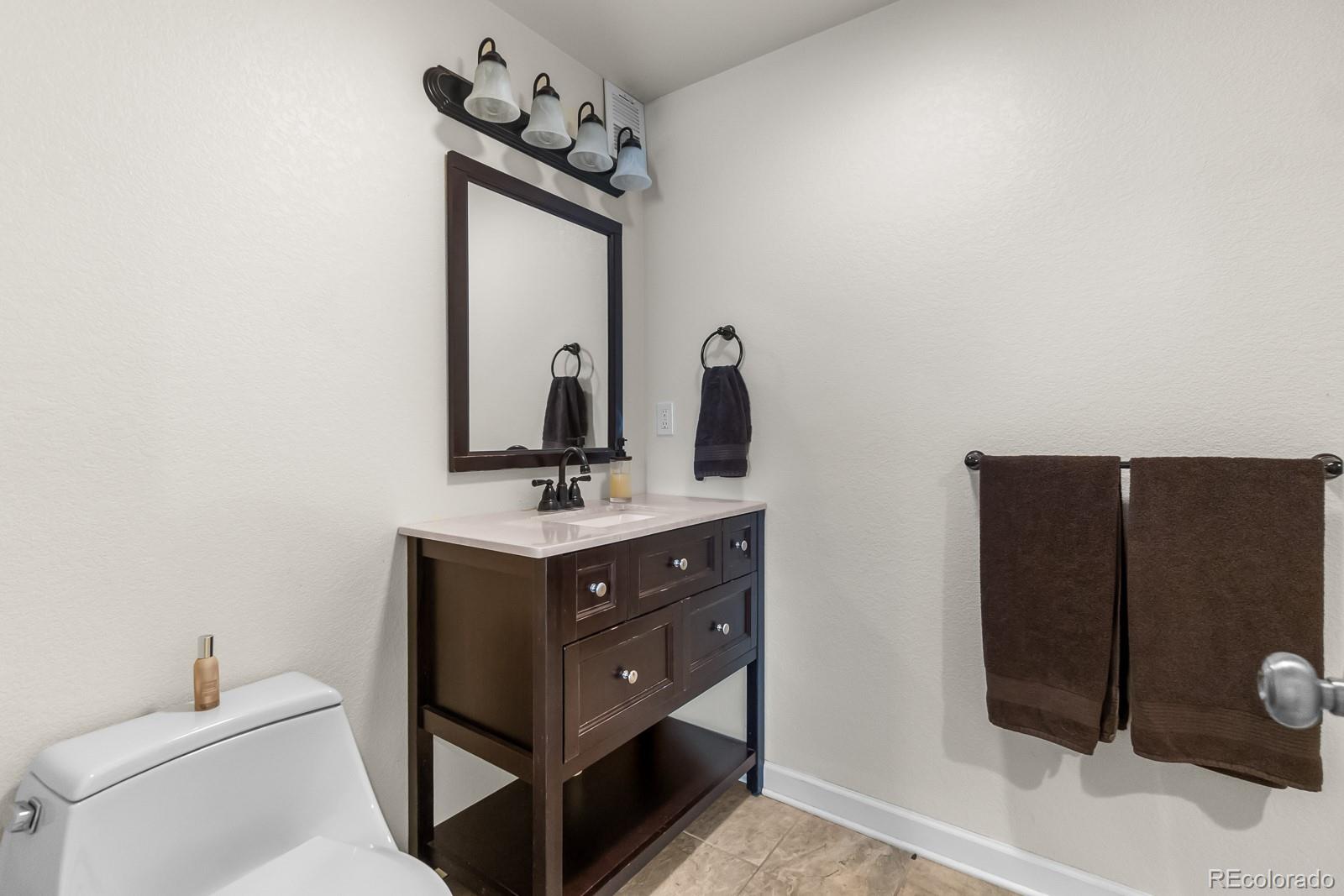3163 Windstream Lane Elizabeth, CO 80107 - Photo 28 of 48 a bathroom with a sink a toilet and mirror