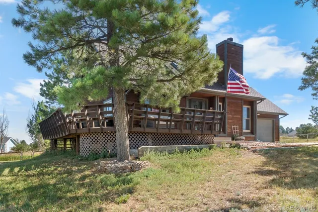 a view of a house with a yard and potted plants