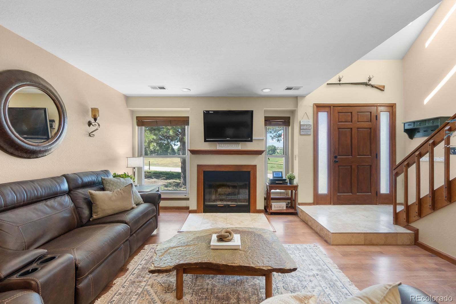 3163 Windstream Lane Elizabeth, CO 80107 - Photo 8 of 48 a living room with furniture a flat screen tv and a fireplace