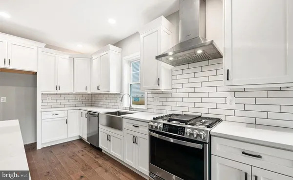 a kitchen with a stove sink and cabinets