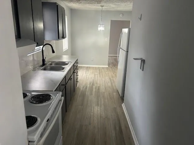a kitchen with wooden floor and stainless steel appliances