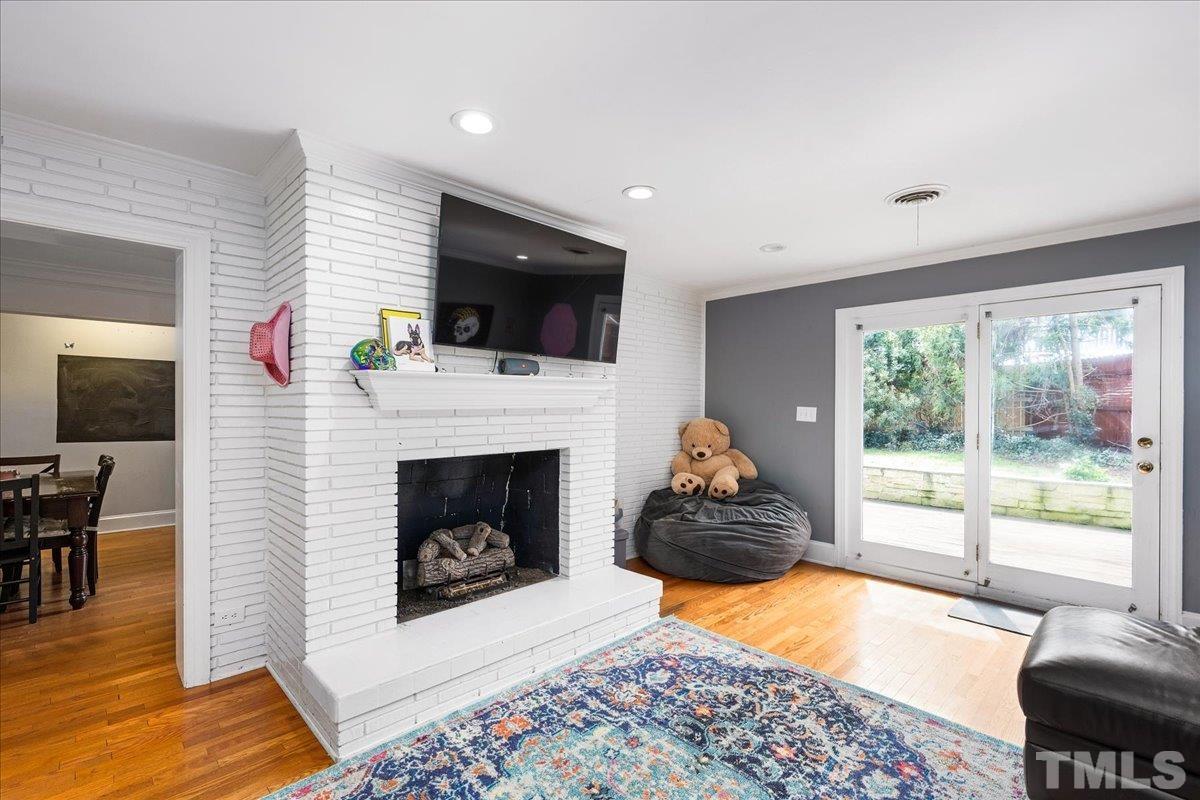 3225 Merriman Avenue Raleigh, NC 27607 - Photo 4 of 19 a living room with furniture a flat screen tv and a fireplace