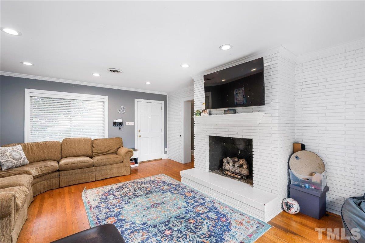 3225 Merriman Avenue Raleigh, NC 27607 - Photo 5 of 19 a living room with furniture a flat screen tv and a fireplace