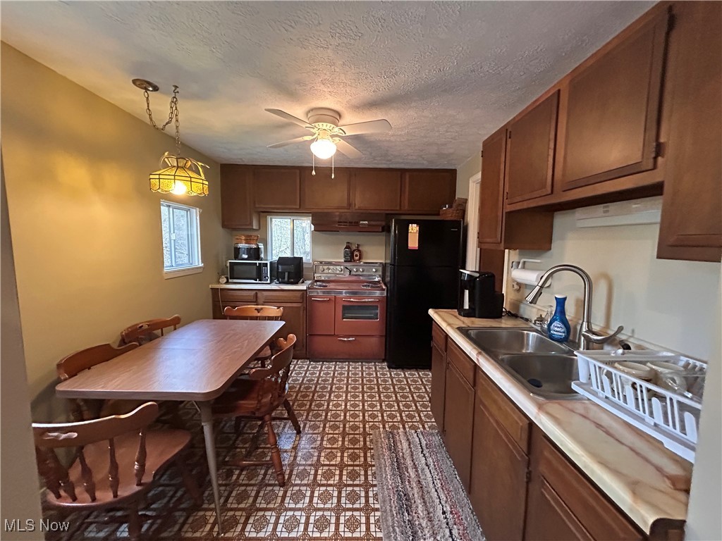 32290 Richey Lane Freeport, OH 43973 - Photo 12 of 20 Kitchen with light countertops, a ceiling fan, a sink, freestanding refrigerator, and electric range oven