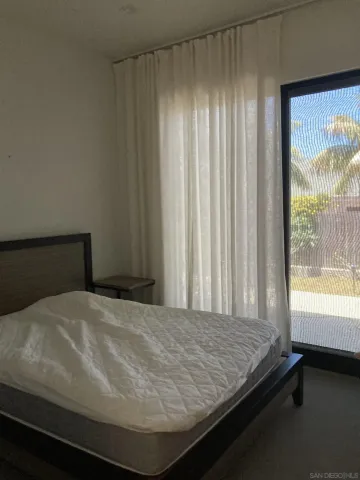 a bed sitting in a bedroom next to a window
