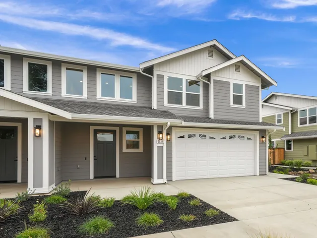 a front view of a house with a yard and garage