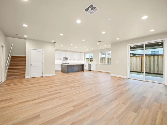 a kitchen with stainless steel appliances kitchen island granite countertop a refrigerator sink and white cabinets