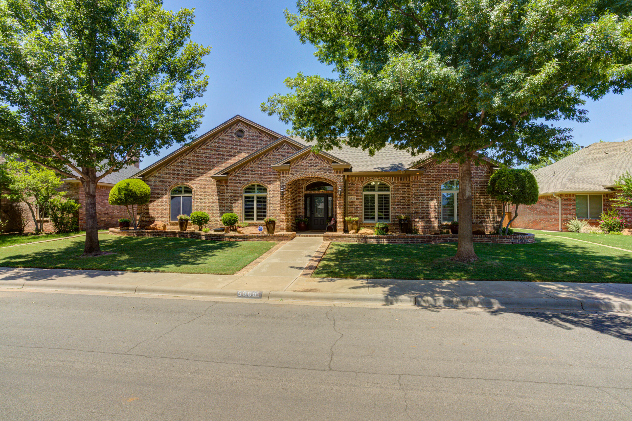 6008 89th Street Lubbock, TX 79424 - Photo 60 of 61 a front view of a house with a garden and trees