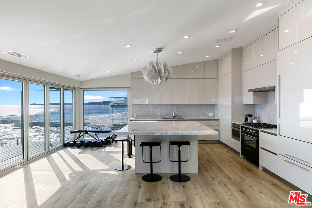 25216 Malibu Road Malibu, CA 90265 - Photo 3 of 21 a kitchen with a stove a sink dishwasher a kitchen island with wooden cabinets and floor