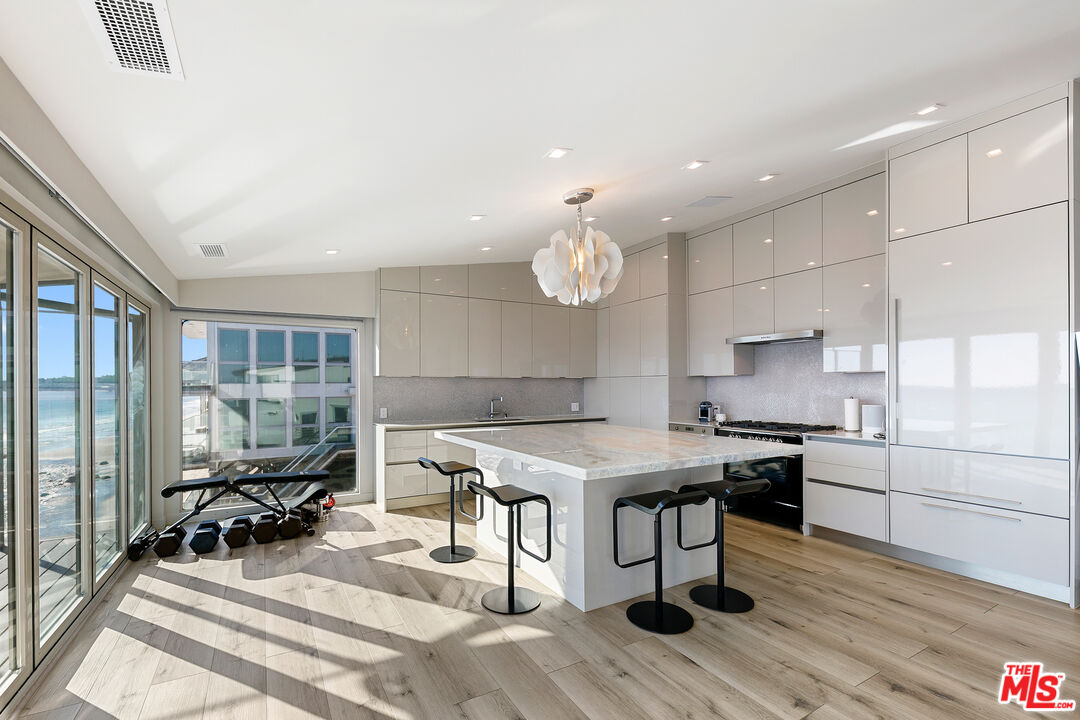 25216 Malibu Road Malibu, CA 90265 - Photo 5 of 21 a kitchen with stainless steel appliances granite countertop a stove oven and a table with chairs