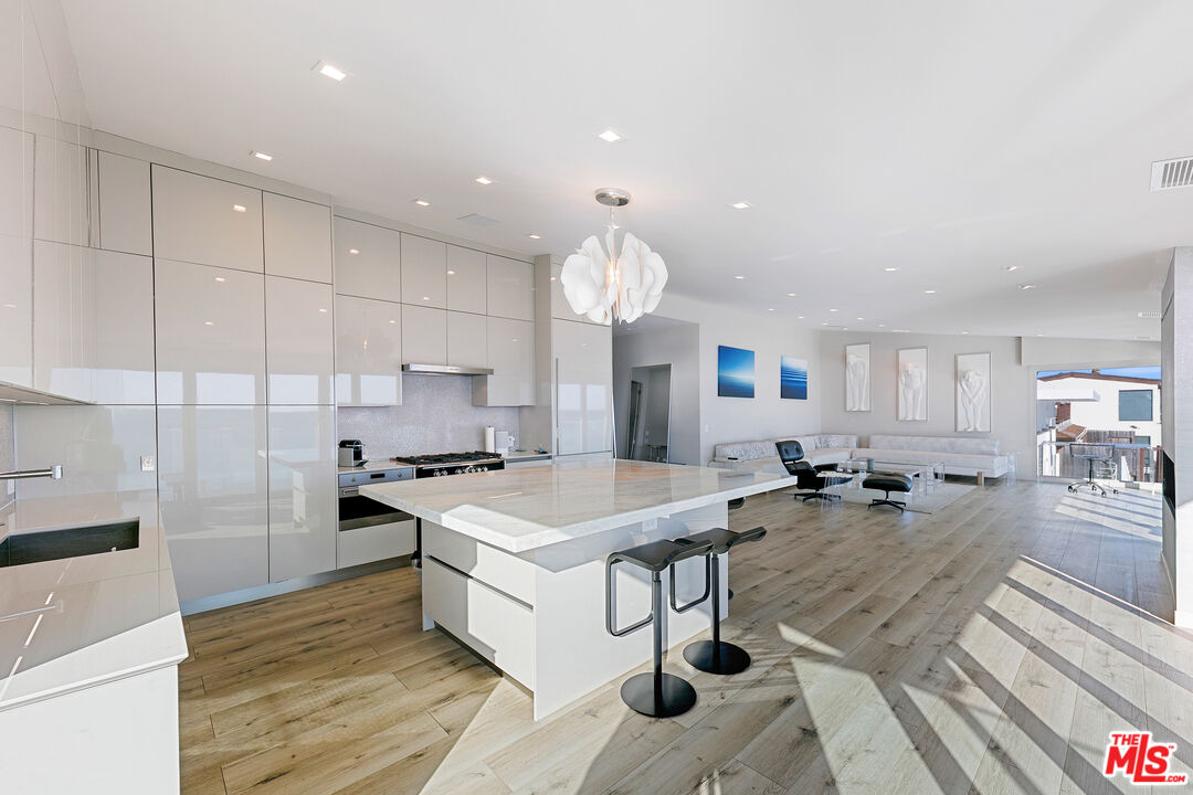 25216 Malibu Road Malibu, CA 90265 - Photo 6 of 21 a kitchen with a dining table chairs sink and white cabinets