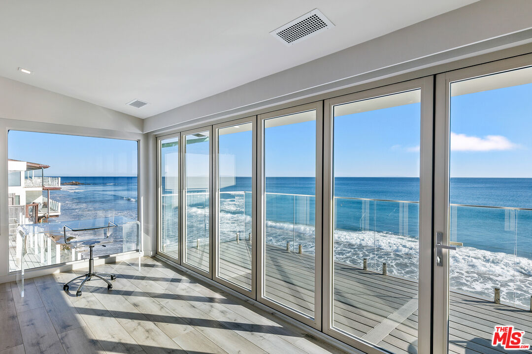25216 Malibu Road Malibu, CA 90265 - Photo 8 of 21 a living room with a floor to ceiling window and wooden floor