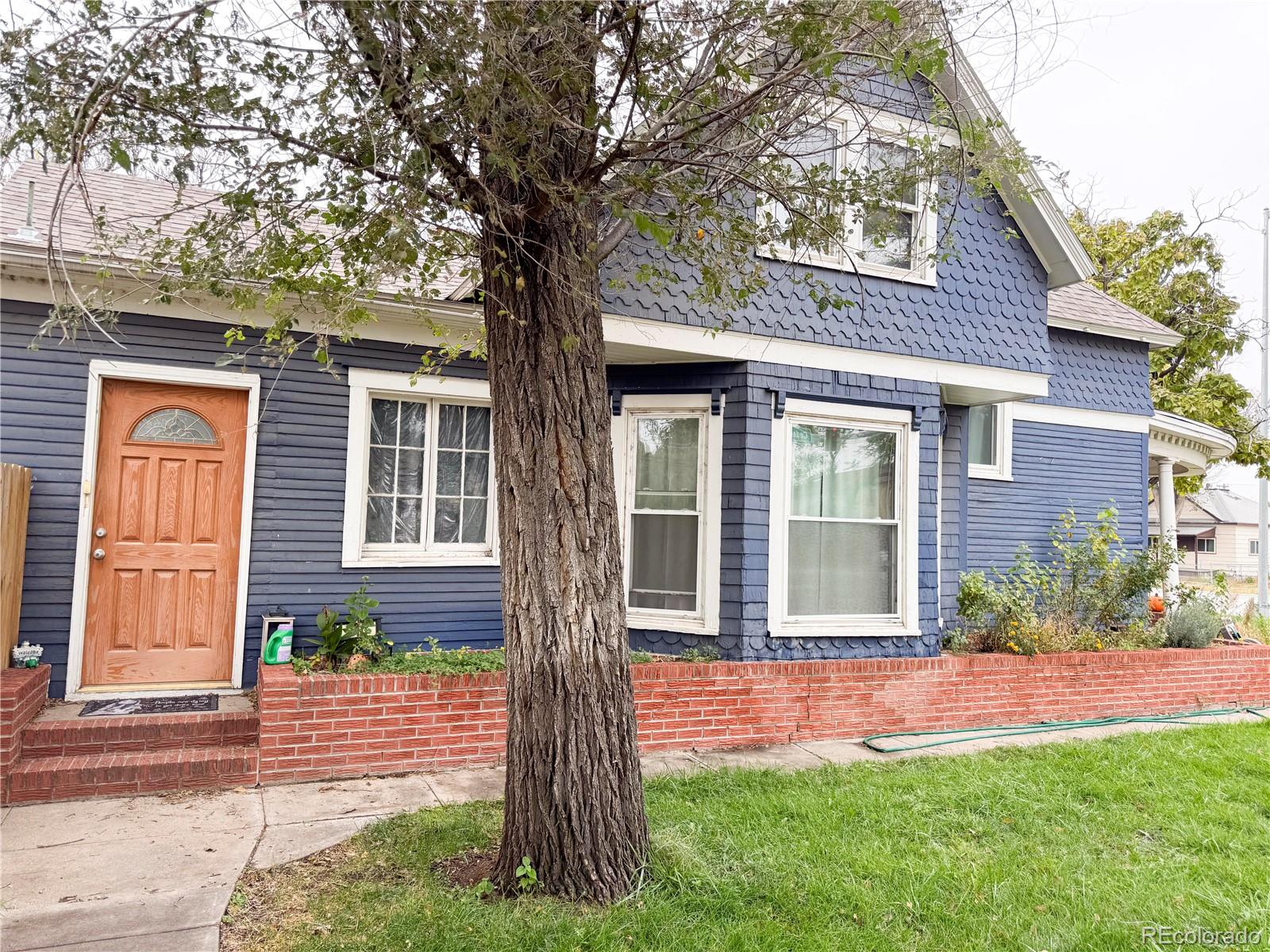 a front view of a house with a yard and potted plants