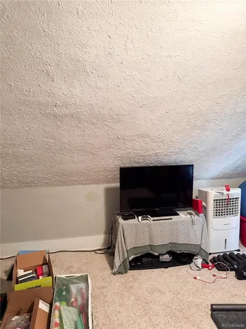 a living room with a flat screen tv and a view of bedroom