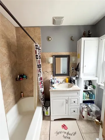 a bathroom with a double vanity sink mirror and bathtub