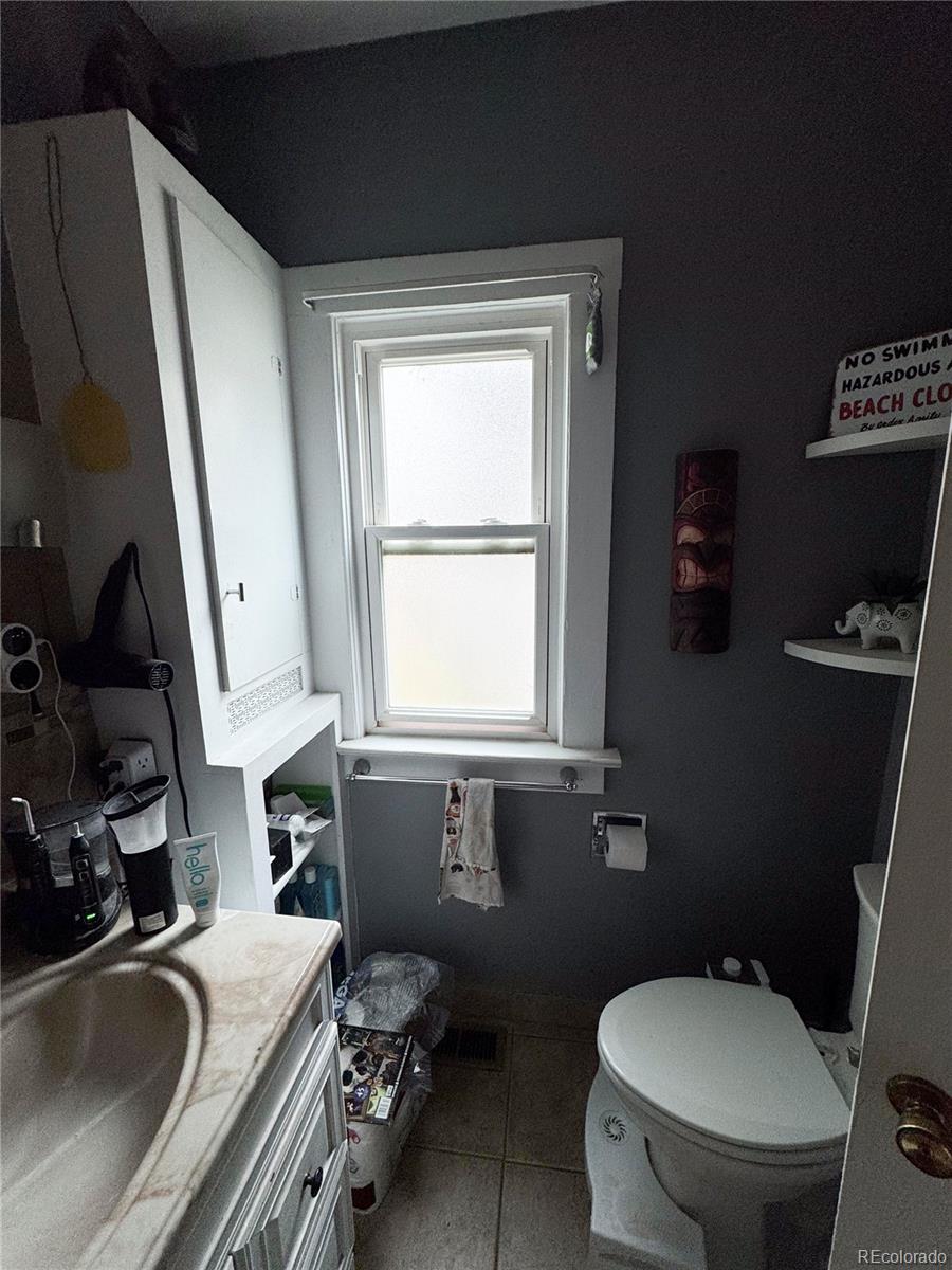 910 South Main Street Lamar, CO 81052 - Photo 9 of 18 a bathroom with a sink a toilet a tub and a window
