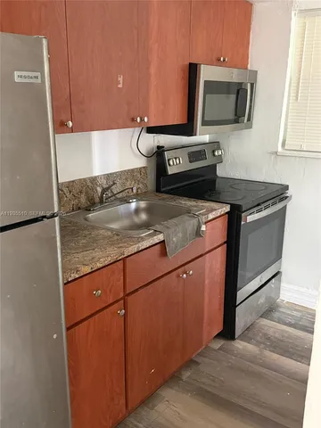 a kitchen with granite countertop a sink and a stove top oven
