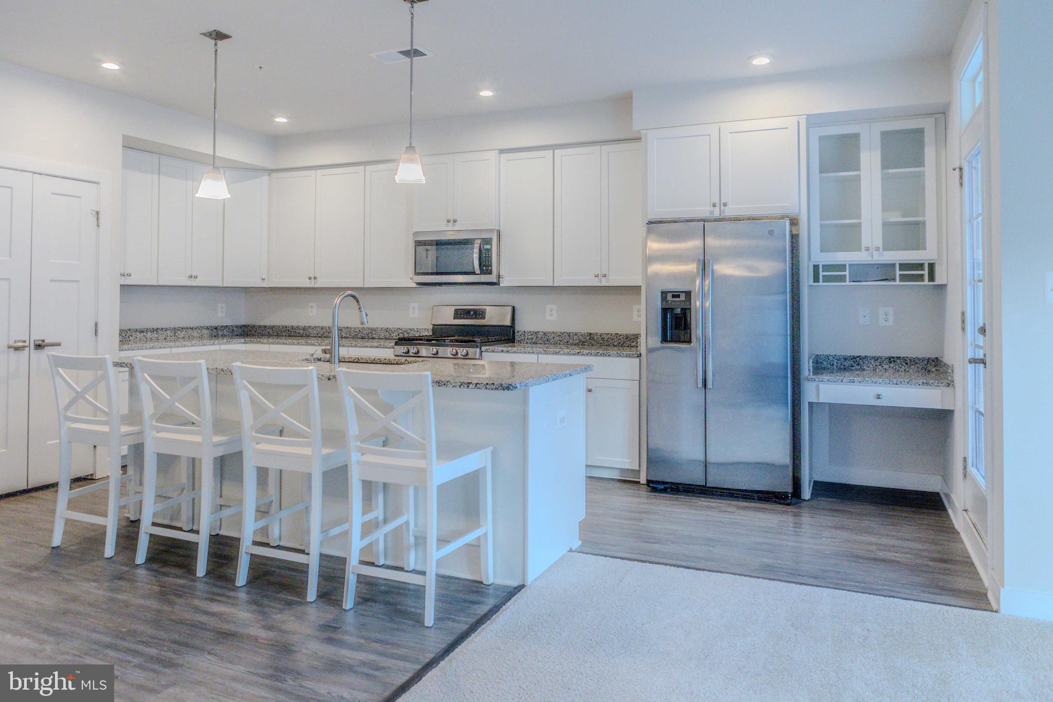 6020 Forum Square Frederick, MD 21703 - Photo 9 of 54 a kitchen with stainless steel appliances kitchen island granite countertop a refrigerator and a stove top oven