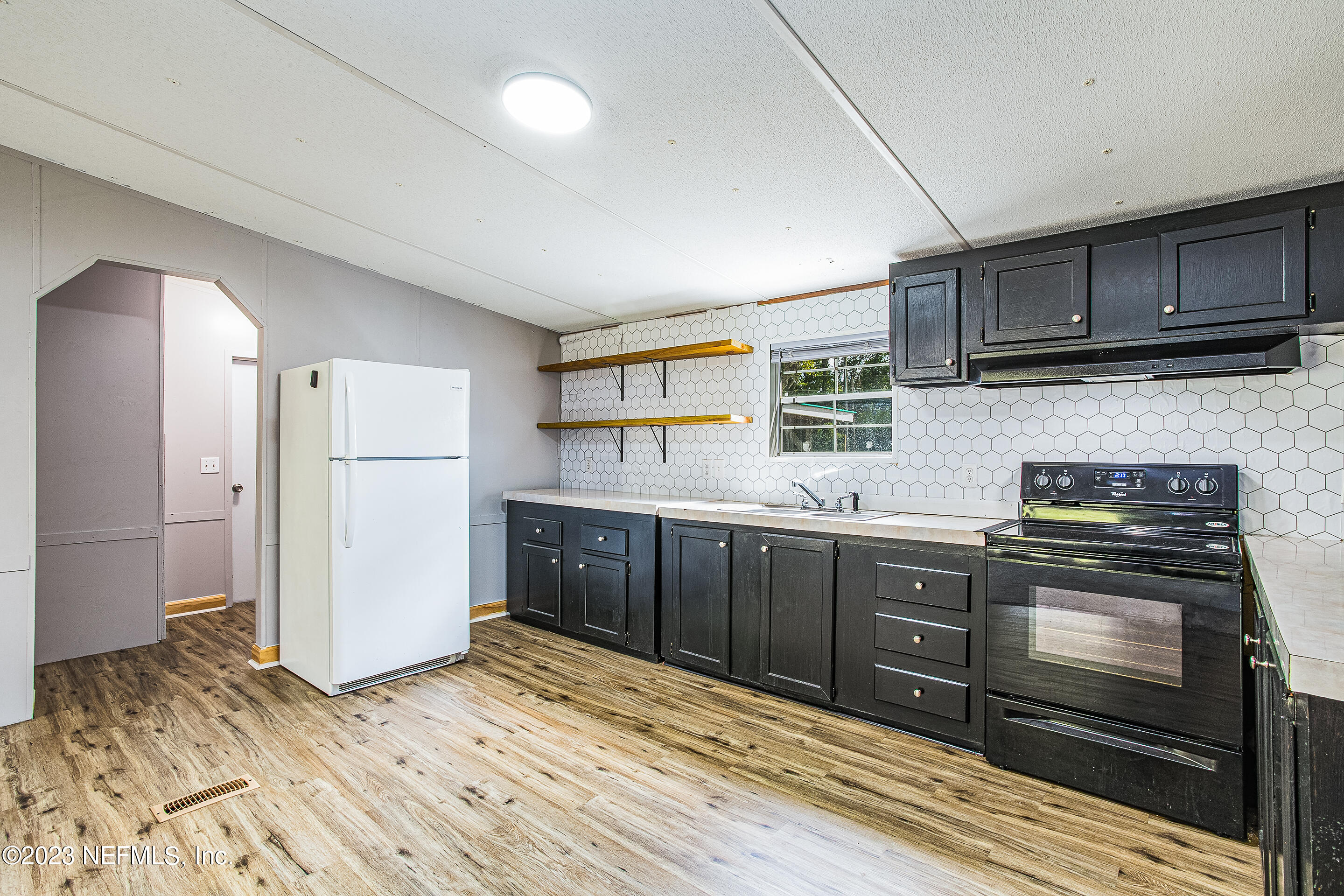 35157 Goodbread Road Callahan, FL 32011 - Photo 17 of 38 a kitchen with granite countertop a refrigerator and a stove top oven
