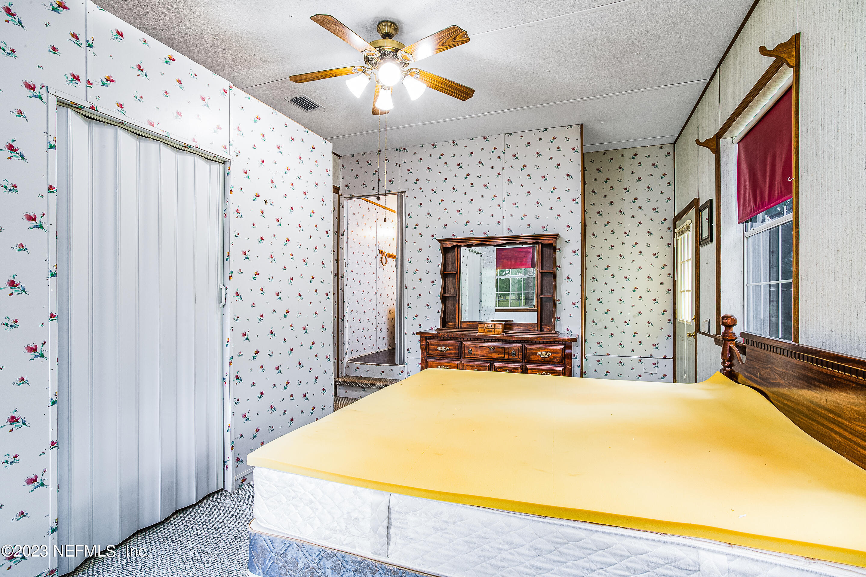 35157 Goodbread Road Callahan, FL 32011 - Photo 27 of 38 a bedroom with a bed and a chandelier