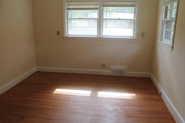 a view of a room with wooden floor and window