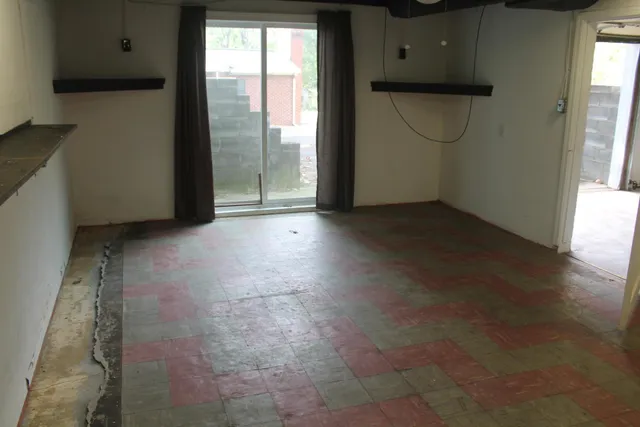 a view of a livingroom with an empty space and a window