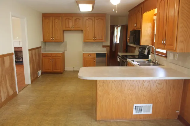 a kitchen with stainless steel appliances granite countertop a sink refrigerator and cabinets