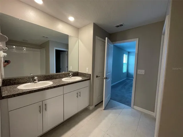 a bathroom with a double vanity sink and mirror