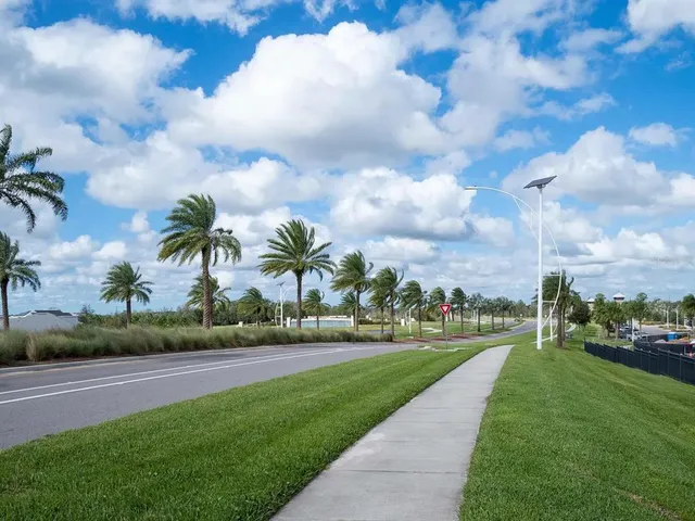 a view of a swimming pool with a lawn chairs under an umbrella