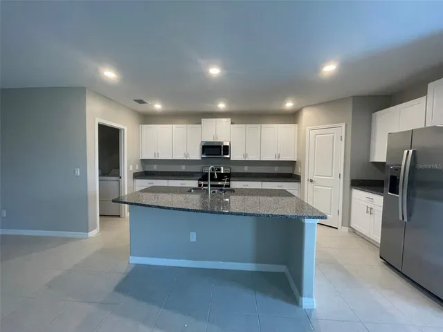 a view of kitchen with refrigerator sink and wooden floor