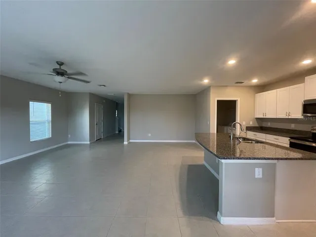 a view of a kitchen with a sink and dishwasher a stove top oven with wooden floor