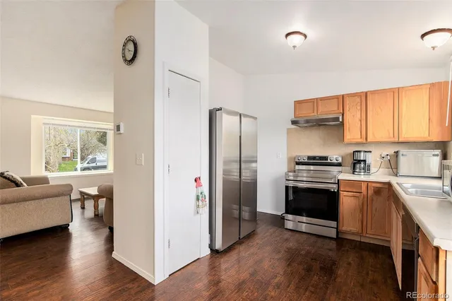 a kitchen with a refrigerator stove and wooden floor
