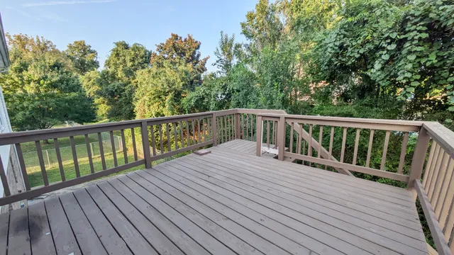 a view of balcony with wooden floor and fence