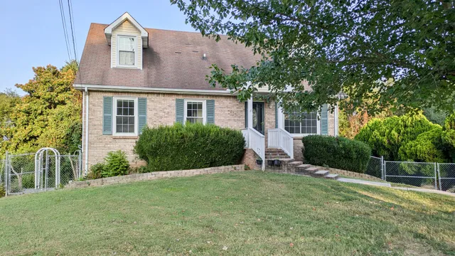 a view of a house with backyard and a tree