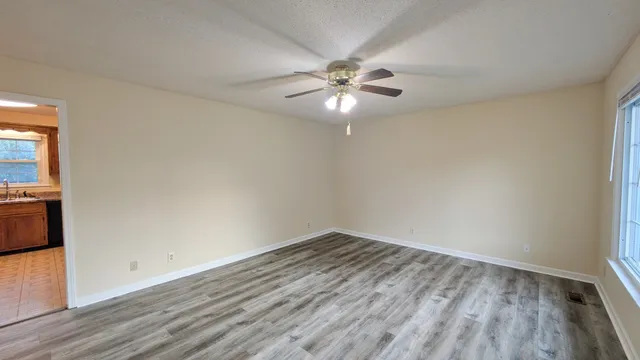 a view of empty room with wooden floor