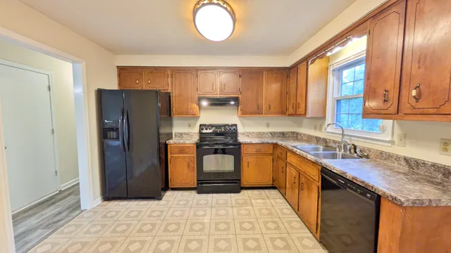a kitchen with stainless steel appliances granite countertop a refrigerator and a sink